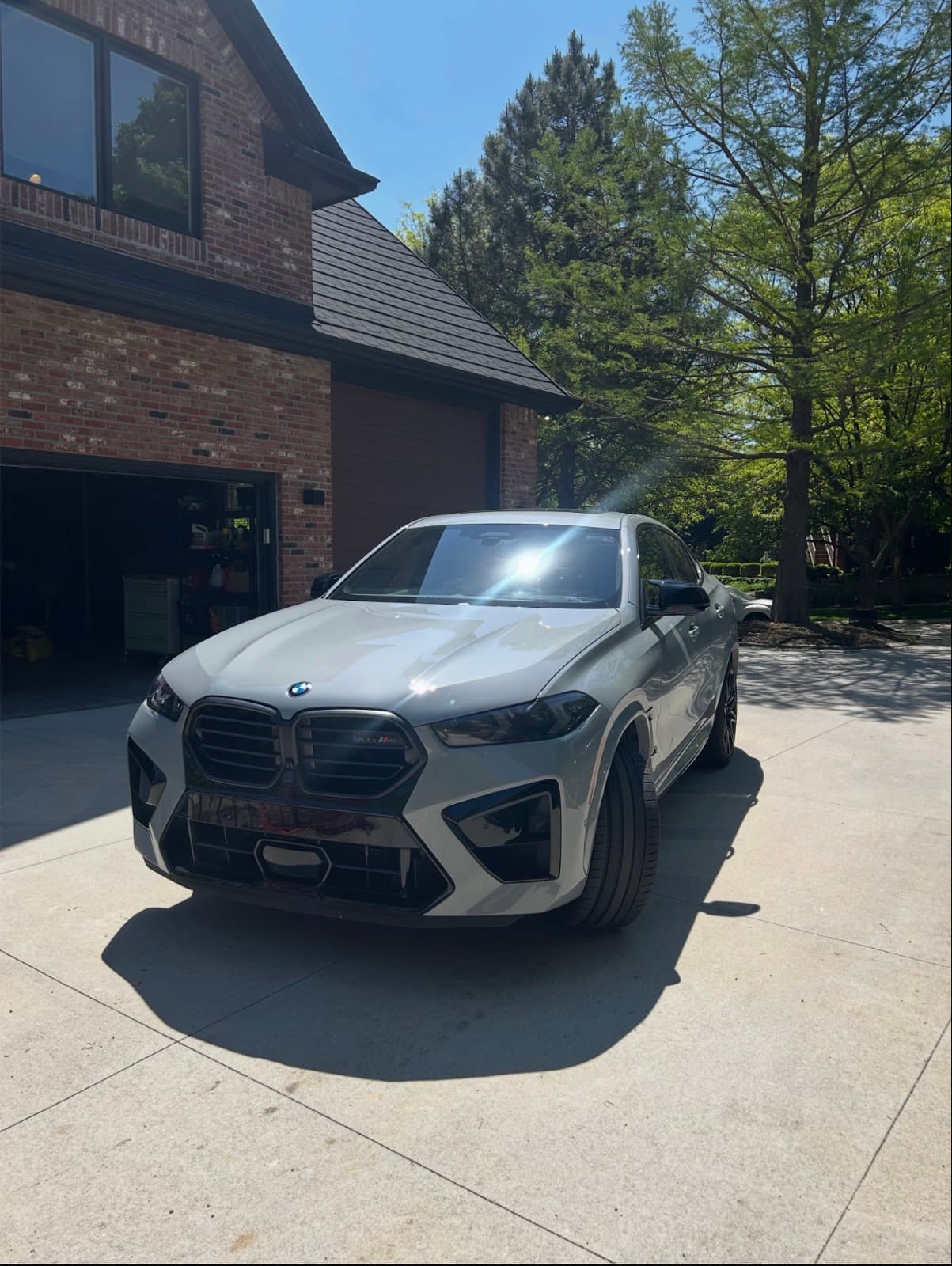 A freshly detailed BMW X6 M parked in a residential driveway after a mobile detail by GlossLab in Prairie Village